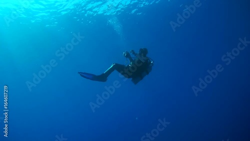 Scubadiver hanging in blue water on the safety stop, and lets bubbles ring - Marsa Alam, Red Sea, Egypt, Africa
 photo