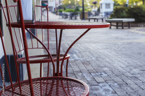 red metal table and chairs on a city sidewalk