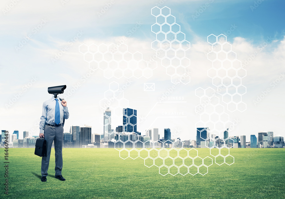 Camera headed man standing on green grass against modern citysca Camera headed man standing on green grass against modern citysca