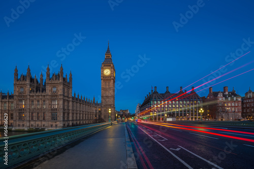 London, England - The famous Big Ben and Houses of Parliament with lights of double decker buses taken on Westminster Bridge at dawn