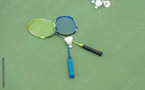 Badminton balls and paddles on a court