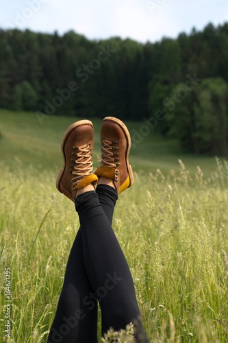 girl in leather shoes lying on the meadow