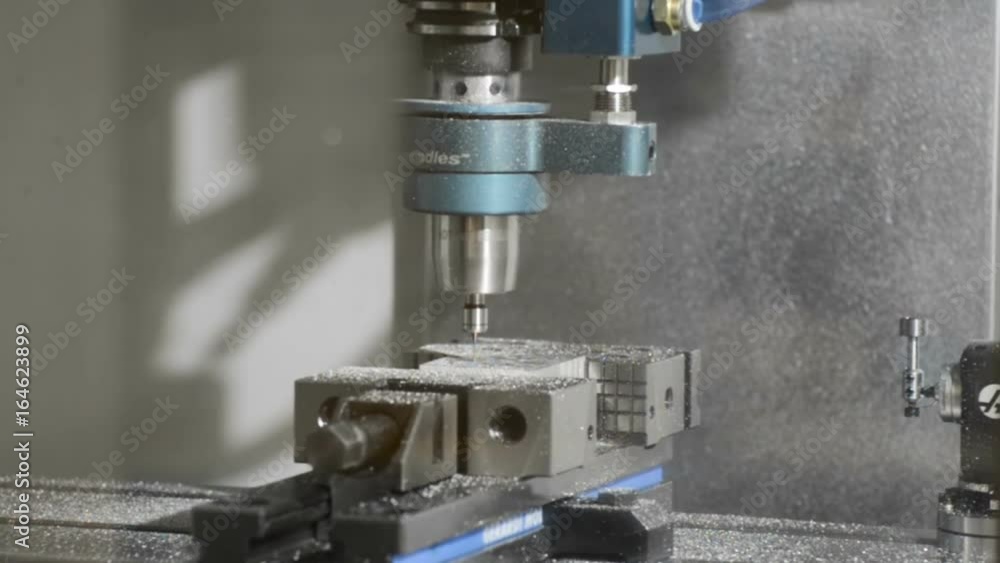 CNC machine engraves metal plate. Engraves the metal workpiece clamped in the machine vice.