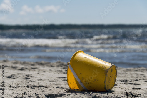 En gul hink på stranden photo
