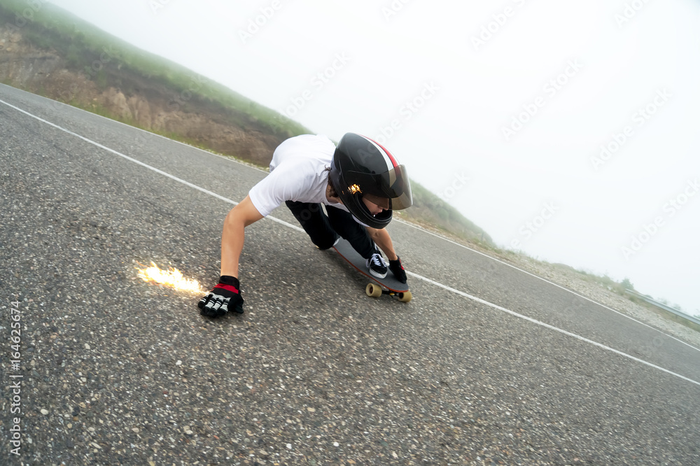 A young guy in a full face helmet in a slide passes a turn