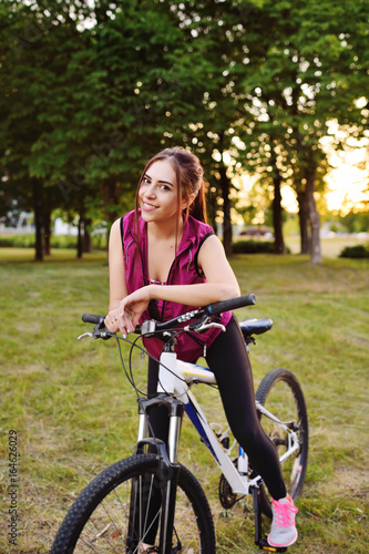 Cute girl riding a bike in the park on a nature background