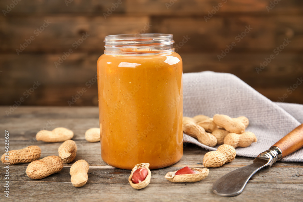 Jar with creamy peanut butter on table Jar with creamy peanut butter on table