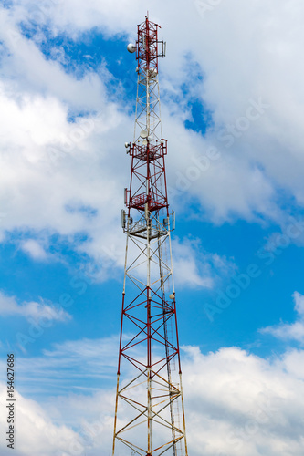 Telecommunication tower on the background of a cloudy sky