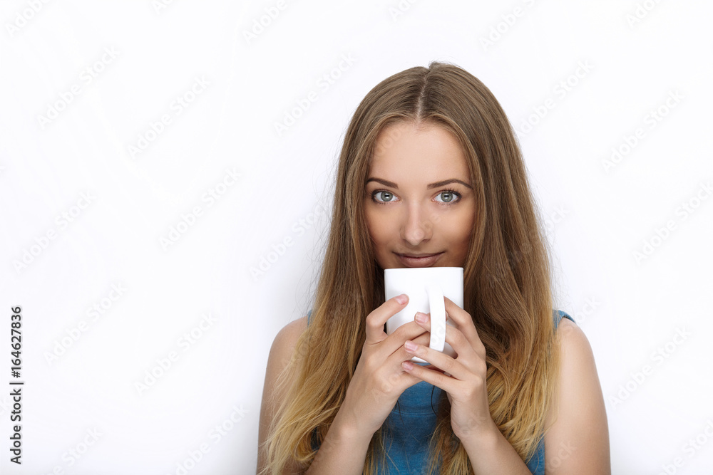 Headshot of young adorable playful blonde woman with cute smile in cobalt color blouse posing with big pure white mug on white backdrop Headshot of young adorable playful blonde woman with cute smile in cobalt color blouse posing with big pure white mug on white backdrop