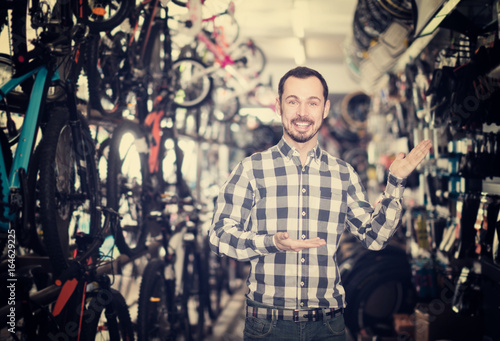 admiring man in bicycle shop chooses for himself sports bike