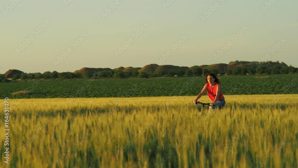 Girl riding a bike outdoors. Girl riding a bike in the field. Girl riding a bike outdoors. Girl riding a bike in the field.
