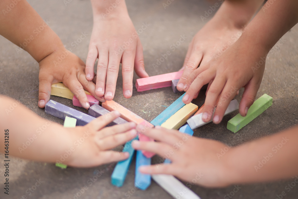 Fototapeta premium Kids hands and chalk, outdoors, closeup