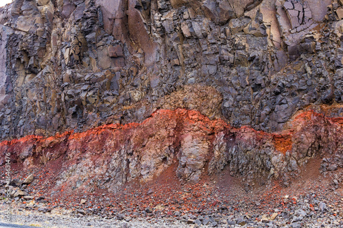 Closeup of red layer of clay between the basaltic layers in Westfjords, Iceland