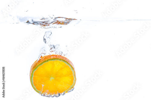 orange slice in water splash. white background