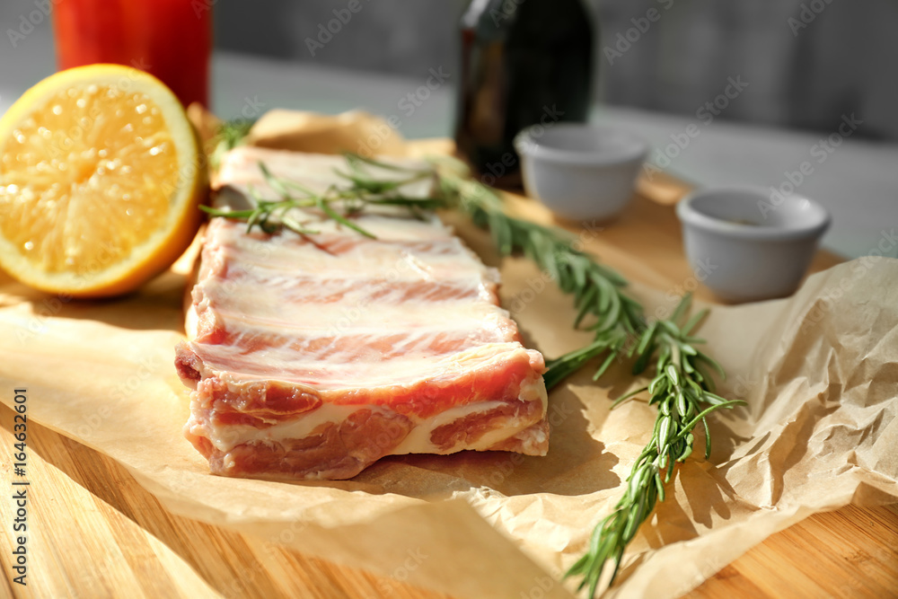 Raw ribs with ingredients on wooden board
