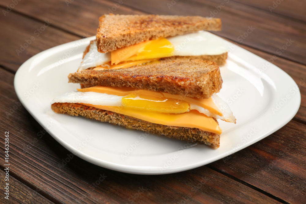 Delicious sandwiches with over easy egg and cheese on kitchen table Delicious sandwiches with over easy egg and cheese on kitchen table