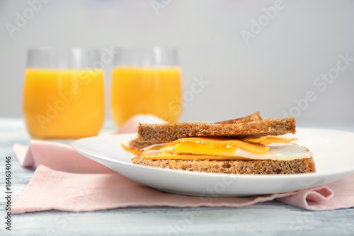 Delicious sandwich with over easy egg and cheese on kitchen table