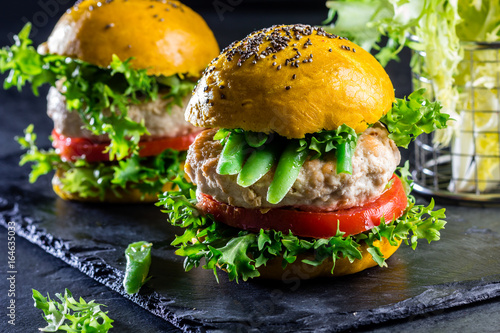 Colored yellow burgers. Chicken burgers hamburgers with turmeric bread