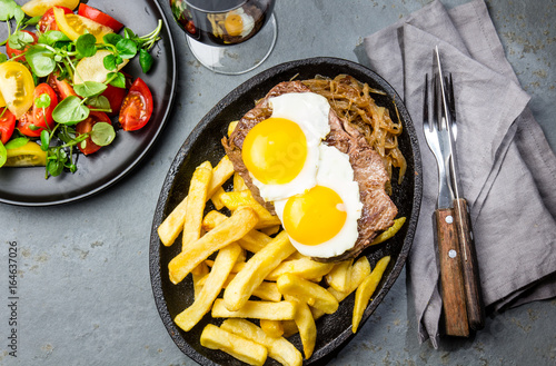 Peruvian Latin American food. Lomo a lo pobre. Beef tenderloin whit fried potatoes french fries and eggs photo