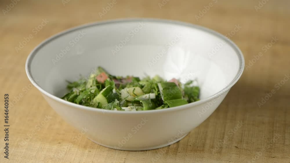 The Russian tasty okroshka with ham and kvass in a white soup plate from porcelain The Russian tasty okroshka with ham and kvass in a white soup plate from porcelain