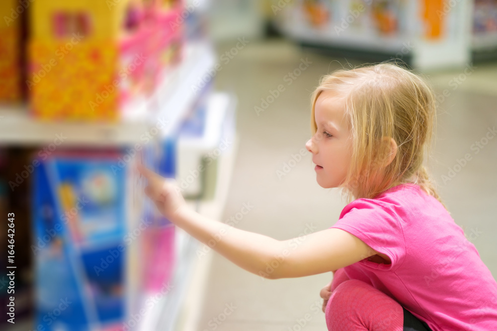 Adorable girl in pink explore toys in kids supermarket Adorable girl in pink explore toys in kids supermarket