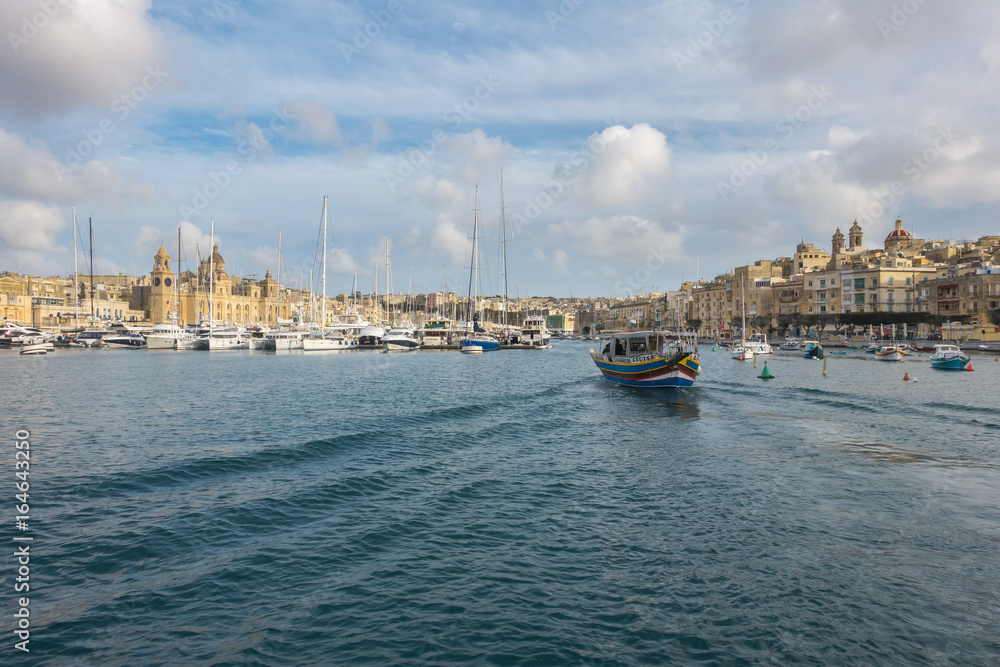  A Luzzu, a traditional maltese fishing boat sailing in Vittoriosa Yacht Marina, Valletta, Malta