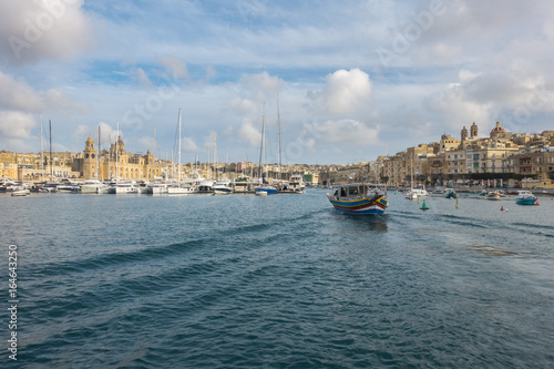  A Luzzu  a traditional maltese fishing boat sailing in Vittoriosa Yacht Marina  Valletta  Malta