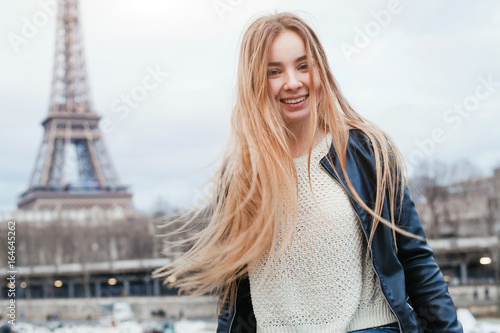 happy young woman in Paris near Eiffel tower, smiling girl traveling portrait, student in Europe