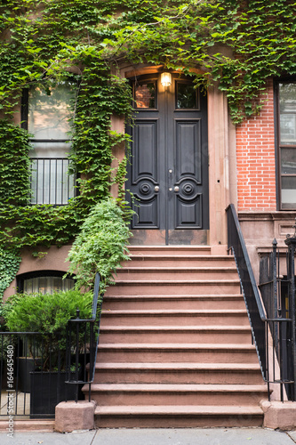 Ivy covered exterior door on New York City brownstone apartment Building  photo
