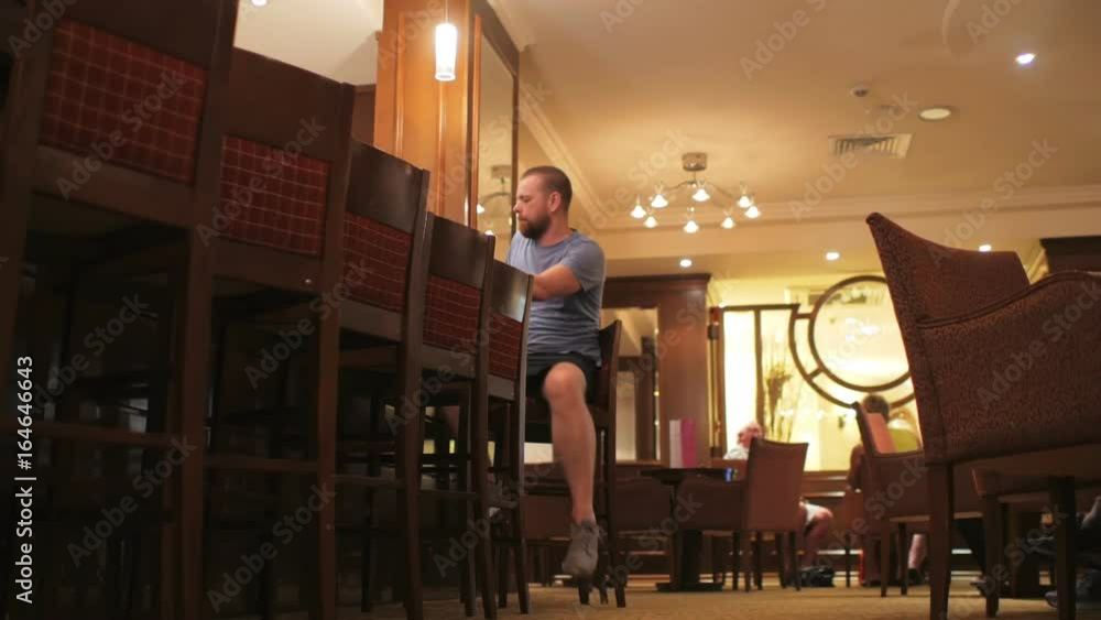 cheerful man sits down at the bar, drinking coffee and fooling around with a mug cheerful man sits down at the bar, drinking coffee and fooling around with a mug