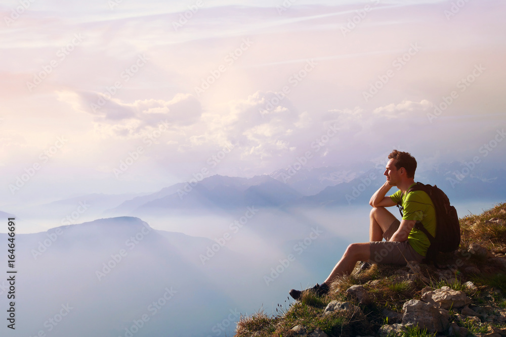 man sitting on top of mountain, achievement or opportunity concept, hiker looking forward on beautiful panoramic landscape man sitting on top of mountain, achievement or opportunity concept, hiker looking forward on beautiful panoramic landscape