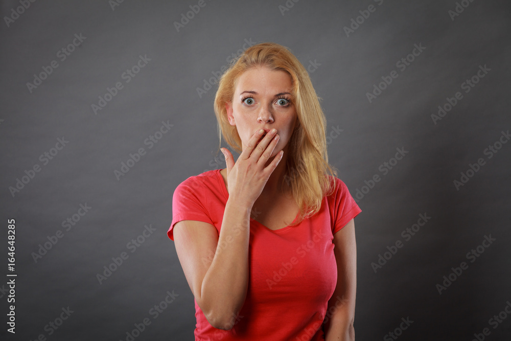 Shocked woman holding hand on lips Shocked woman holding hand on lips