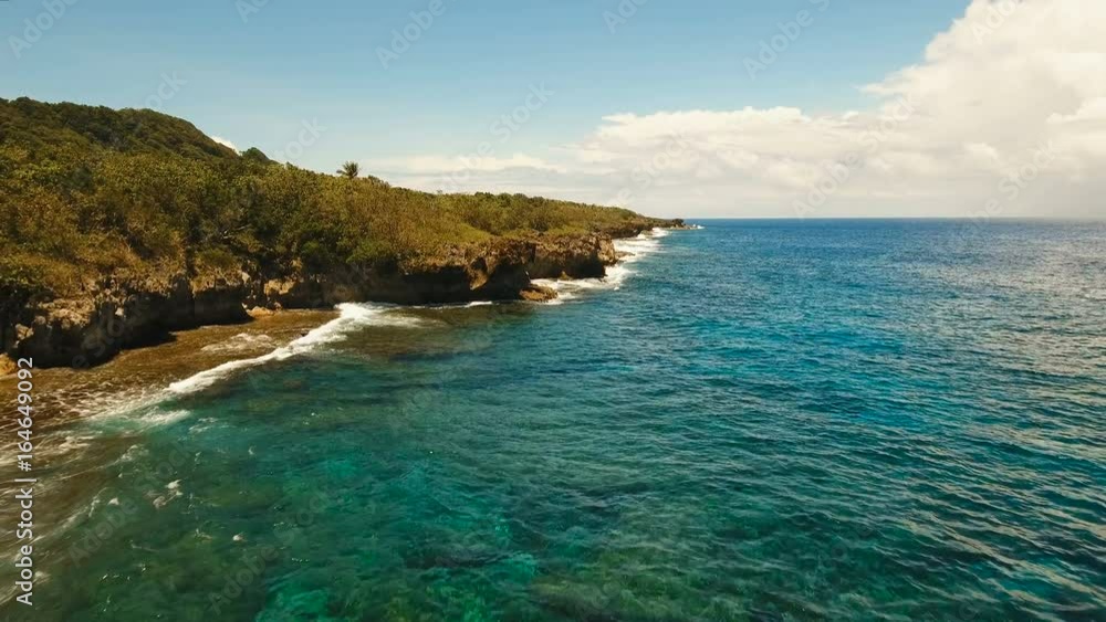 Rocky coast line of Island Siargao. Aerial view sea rocky coast, waves breaking to the rocky shore. Sea landscape, rocks, waves breaking about the shore. Rocky coastline. Philippines. 4K video. Travel Rocky coast line of Island Siargao. Aerial view sea rocky coast, waves breaking to the rocky shore. Sea landscape, rocks, waves breaking about the shore. Rocky coastline. Philippines. 4K video. Travel