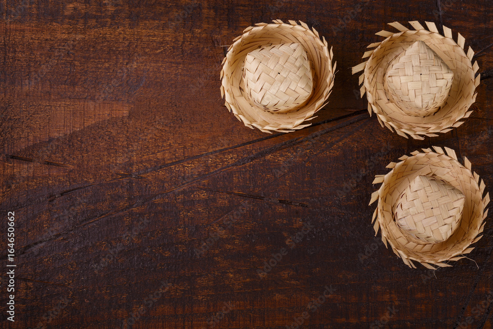 Wooden background with wicker hat for brazilian festivel Festa Junina Wooden background with wicker hat for brazilian festivel Festa Junina