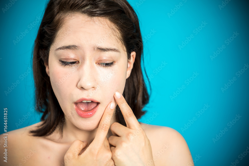 Fototapeta premium young woman who checks her skin. acne treatment.