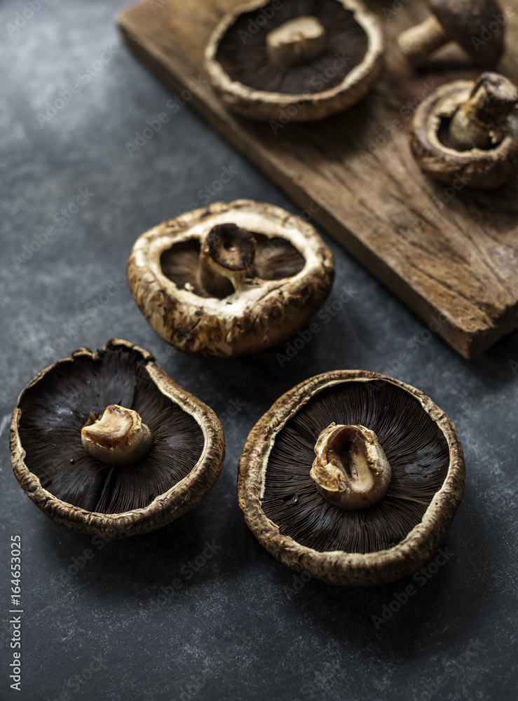 Closeup of fresh bunch of portobello mushroom on grunge black table Closeup of fresh bunch of portobello mushroom on grunge black table