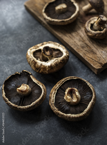 Closeup of fresh bunch of portobello mushroom on grunge black table