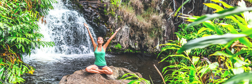 Yoga nature waterfall wellness retreat woman banner meditating. Meditation happy girl with open arms in serenity enjoying lush forest outdoors  mindfulness concept. Banner panorama crop.