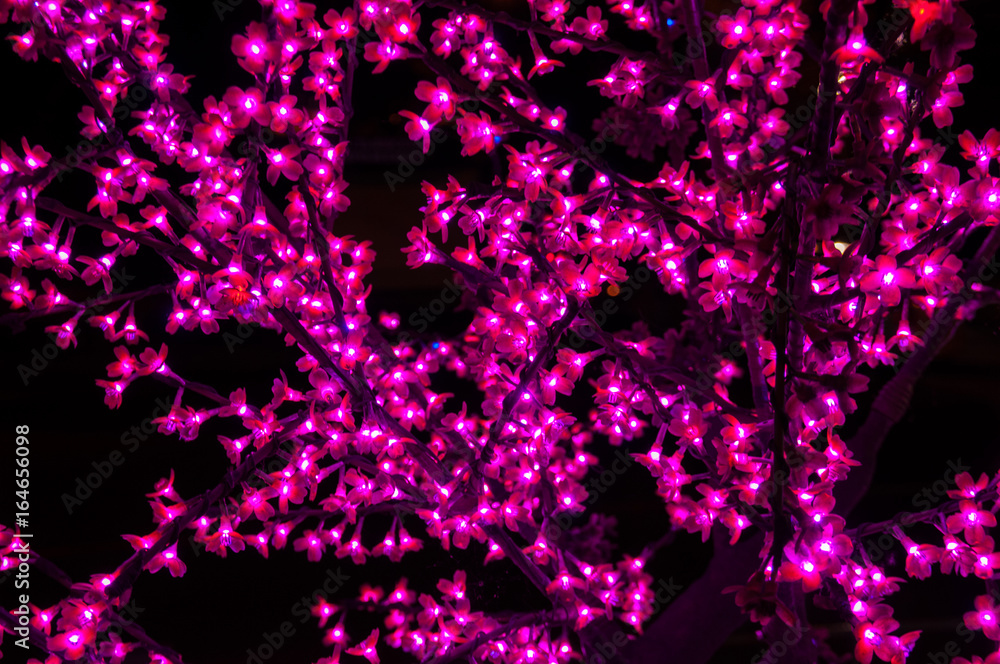 Neon artificial red flowers on a black background Neon artificial red flowers on a black background
