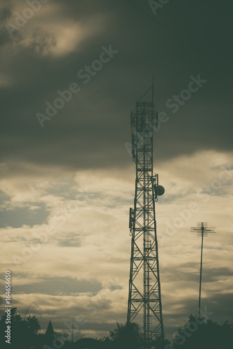 Antenna of cellular and communication system tower with the blue sky and cloud. vintage tone.