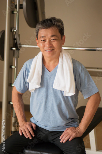 healthy, happy, smiling, positive senior well being asian man working out in gym