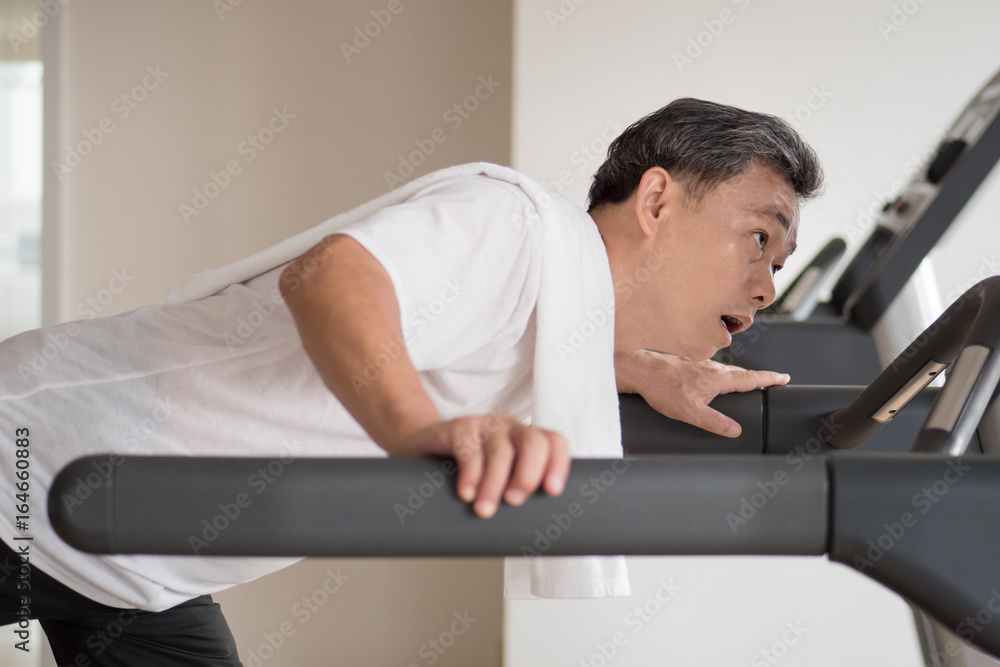 Fototapeta premium exhausted senior man in gym threadmill