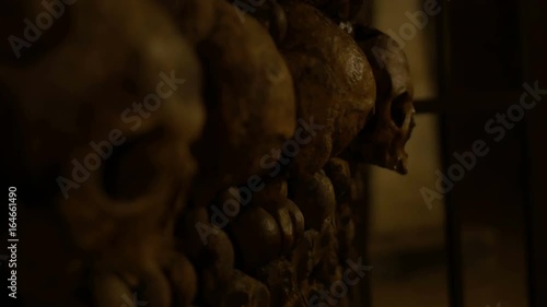 Rack focus shot of human skulls in an underground ossuary. Halloween / horror / nightmare. 4K rack focus shot. photo