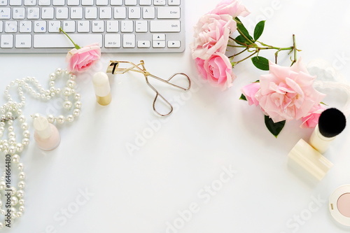 Flat lay, top view office feminine desk, female make up accessories, workspace with laptop and bouquet roses.Beauty blog concept.Copy space