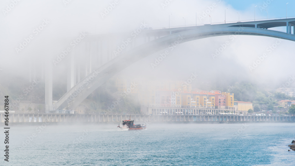 Obraz premium Porto in Portugal, view of the Douro river in the mist, with a traditional boat 