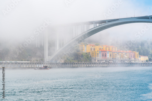 Porto in Portugal, view of the Douro river in the mist, with a traditional boat 