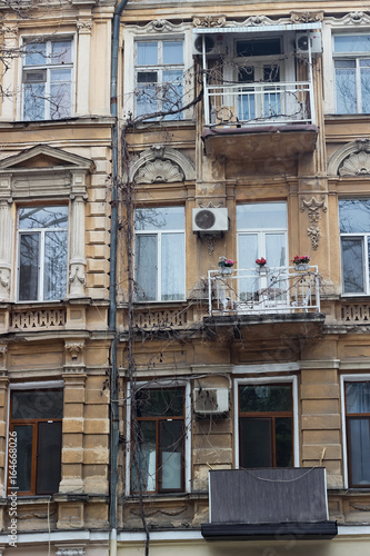 Facade of an old house with three balconies in Odessa. Old facade, windows, balconies, columns. Architectural detail.
