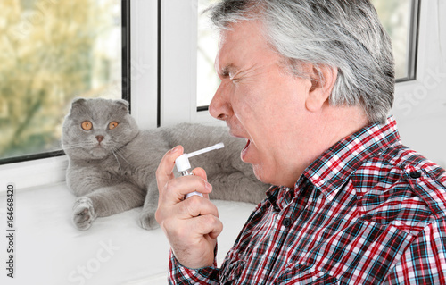 Sick senior man using throa...