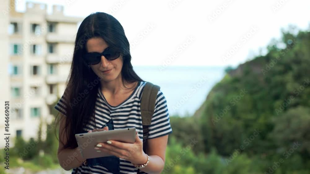 Female traveler is looking on digital tablet. Female traveler is looking on digital tablet.