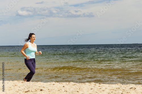młoda atrakcyjna dziewczyna biega na plaży